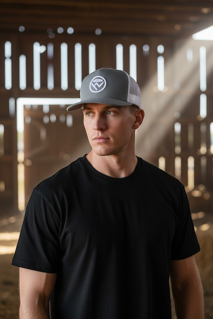 Haze N Handle grey trucker hat with white embroidered logo and white mesh back, worn by a man.