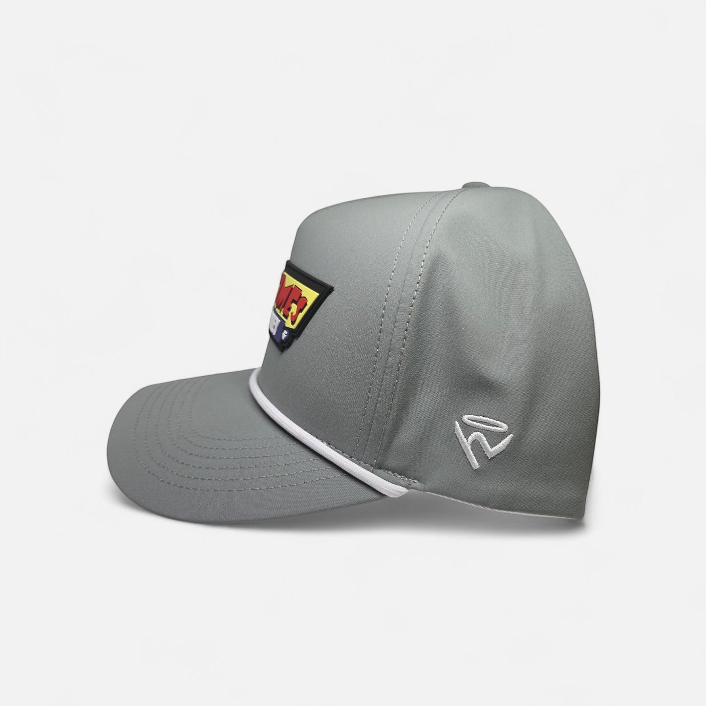 Haze N Handle stone-gray structured baseball cap with white rope detail and a bold red, yellow, and blue embroidered patch.