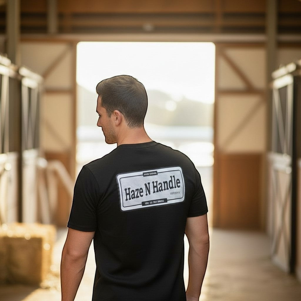 Black cotton t-shirt with a large vintage badge graphic on the back and small sleeve branding. Haze N Handle.