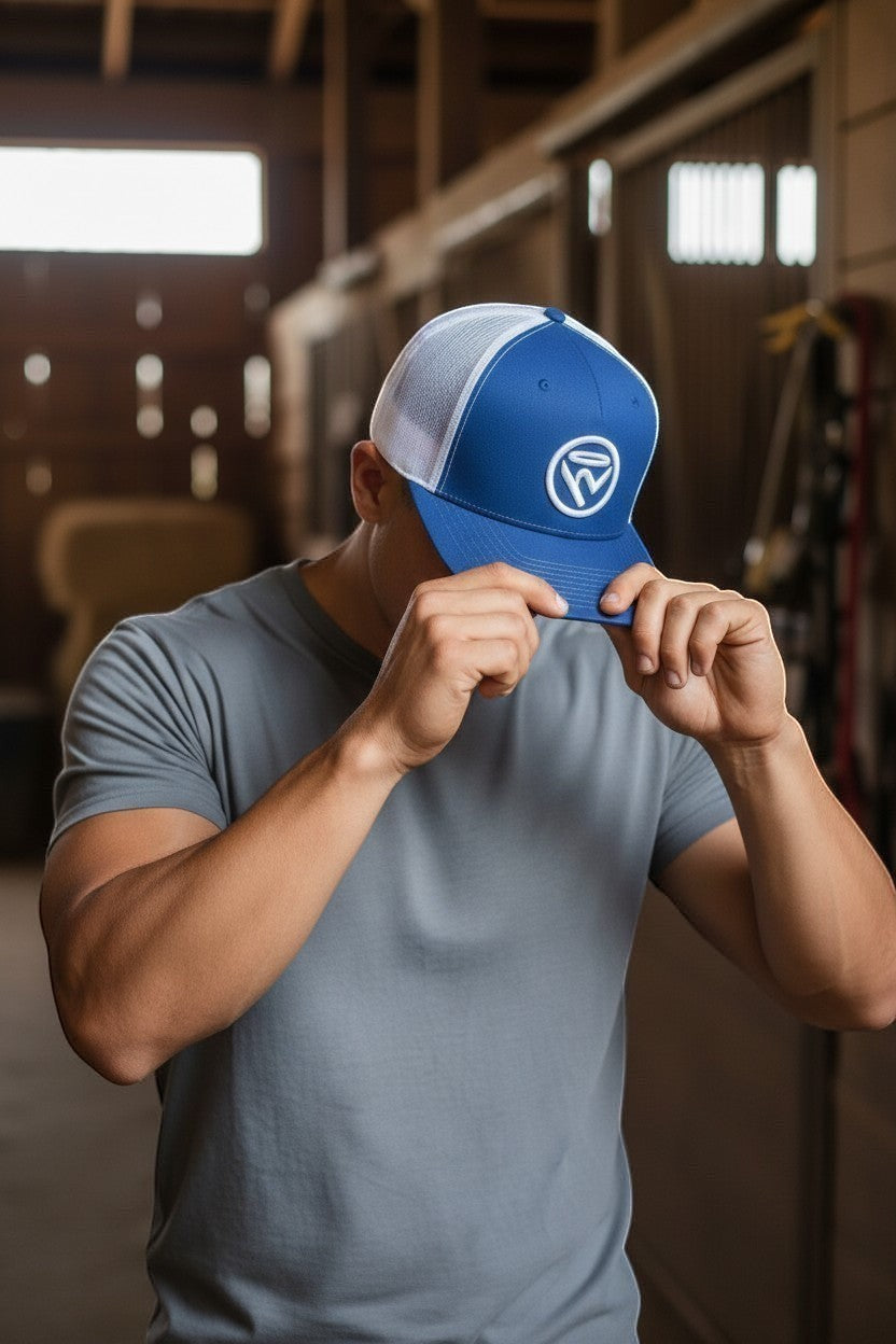 Haze N Handle blue trucker hat with white mesh back and embroidered logo, worn by a man in a grey t-shirt.