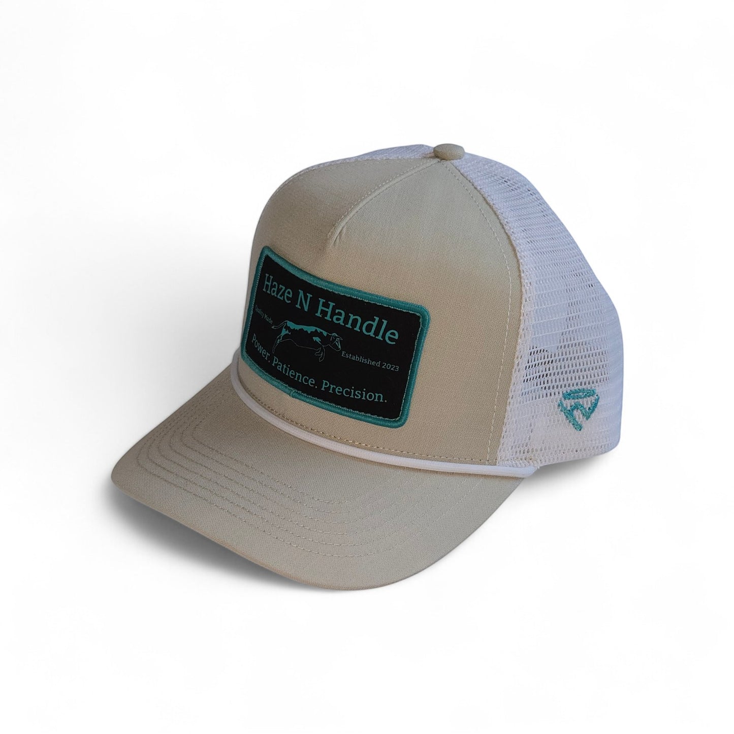 Haze N Handle stone trucker hat with white mesh back, rope detail, and embroidered teal and black patch.